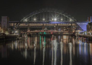 Newcastle, İngiltere - 13 Nisan 2025 Tyne Köprüsü, Swing Köprüsü ve Tyne Nehri 'ni Tyne ve Gateshead' e bağlayan yüksek seviye köprüyle Newcastle 'ın Tyne ve Gateshead' i birbirine bağlayan muhteşem gece manzarası. Duvar kağıdınız olarak kullanın.