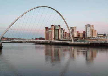 Newcastle, İngiltere - 13 Nisan 2025 - Baltık un değirmenleri ve Iconic gateshead milenyum köprüsünün günbatımından sonra arka planda gökyüzü ile Tyne Nehri 'ni kaplayan güzel manzarası. Nehirde yansıması olan yaya köprüsünü duvar kâğıdı olarak kullanın., 