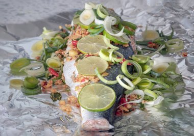 Alüminyum folyoyla pişirilmiş somon balığı hazırlayın. Malzemeler arasında kişniş kökü, Ginger, Galangal, Kaffir limonu, Leek, ve somon balığının üzerine dilimlenmiş limon dilimlenmiş kuş gözü biberi yer alıyor. Sağlıklı beslenme, duvar kağıdın olarak kullan.