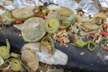 Biftek kökü, zencefil kökü, Ginger, Galangal, Kaffir limonu, Leek ve somon balığının üzerine dilimlenmiş limon dilimlenmiş kuş gözü biberi içeren fırınlanmış somonun yakın çekimi. Sağlıklı beslenme, duvar kağıdı, poster ve boşluk olarak kullanın..