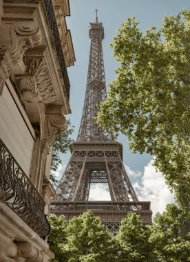 Paris 'teki Rue de L' Universite 'den Ultimate Eiffel Tower View. Paris 'te, Rue de l' Universite caddesinde ağaçlar ve tipik Paris binaları arasında Eyfel Kulesi 'nin mimarisini gösteren bir arka sokak. Boşluğu kopyala.