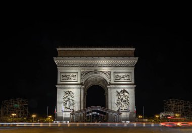 Fransa, Paris - 2 Mayıs 2025 - Paris 'in merkezindeki Ünlü Zafer Takı' nın (Zafer Kemeri) Nightscape görünümü ve Elysees 'deki trafik yolları. Zafer ve tarihi mirasın sembolü, İkonik turistik mimari dönüm noktası.