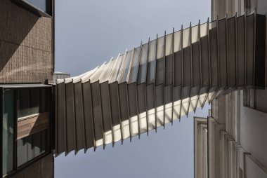 Londra, İngiltere - 13 Mayıs 2025 - Çarkıfelek Gökyüzü Köprüsü 'nün fütüristik modernizmine bakarak Kraliyet Opera Binası' nı Covent Bahçesi 'ndeki Kraliyet Bale Okulu' na bağlıyorum. Gökyüzü arka planlı Aspirasyon Köprüsü 'nün dış mimari tasarımı, Sersemletici Geçiş