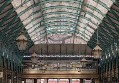 Londra, İngiltere-13 Mayıs 2025 - Covent Garden Market Salonu 'nun tavanında asılı demir cam çatı ve fenerler ile mimari Greko-Romen tarzı. Metalik çerçeve çatısı tavan lambasıyla görünümü, bunu duvar kağıdı, poster ve boşluk olarak kullanın