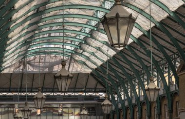 Londra, İngiltere-13 Mayıs 2025 - Covent Garden Market Salonu 'nun tavanında asılı demir cam çatı ve fenerler ile mimari Greko-Romen tarzı. Metalik çerçeve çatısı tavan lambasıyla görünümü, bunu duvar kağıdı, poster ve boşluk olarak kullanın