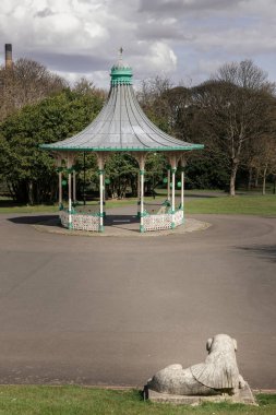 Newcastle, İngiltere - 13 Nisan 2025 - Bir Orkestra Sahnesi ve Bir Tribün Görünümü. Leazes parkına monte edilmiş Viktorya dönemi orkestrasının modern bir kopyası. Arka planda yeşil ağaçlar olan Müzik Pavyonu, bunu duvar kağıdınız olarak kullanın..