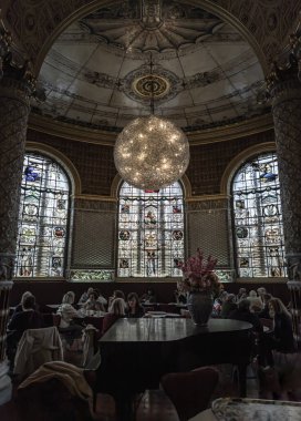 Londra, İngiltere - 07 Mayıs 2025 - Londra 'daki The V & A (Victoria ve Albert Müzesi) içindeki The Gamble Room' da toplanan insanlar ve turistler ve öğleden sonra çayının keyfini çıkarıyorlar. Dünyanın en eski müze restoranının muhteşem iç manzarası..