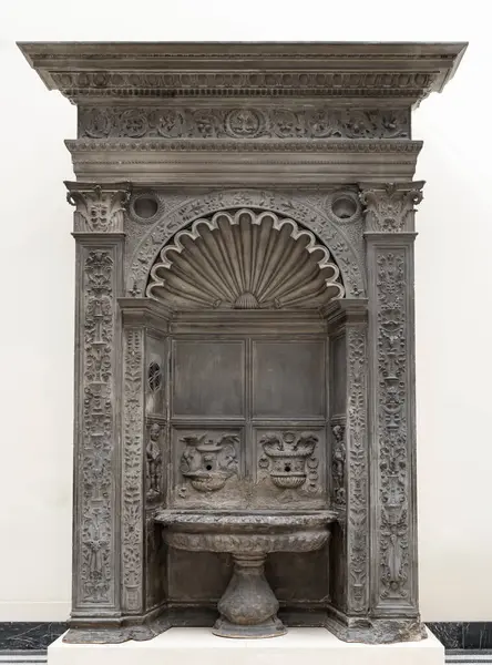 Bir su fıskiyesi veya Acquaio gri kumtaşı oyulmuş, her iki tarafında iki pilaster tarafından çerçevelenmiş eliptik bir leğen, yukarıda bir kalıp ve Londra 'daki Victoria ve Albert Müzesi' nde sergilenen bir duvar fıskiyesi ve bir friz var..