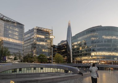 Londra, İngiltere - 27 Nisan 2025 - The scoop, the amphiatre next the GLC building, at More London with the Shard and other Modern glass buildings behind. Londra şehrinde gün batımından sonraki çarpıcı manzara. Duvar kağıdı, poster ve kopyalama alanı olarak kullan.