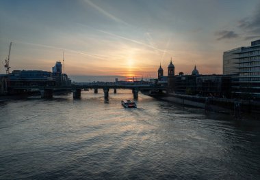 Londra, İngiltere - 27 Nisan 2025 - Cannon caddesi tren istasyonu köprüsünün etkileyici bir görüntüsü ve arkasında Cruise teknesi ve renkli gökyüzü. Duvar kağıdı olarak kullan, Poster ve Kopyala alanı, Seçici odak.