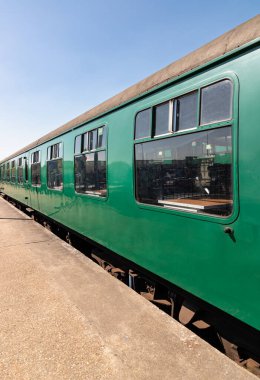 Royal Tunbridge Wells, İngiltere - 29 Nisan 2025 - Tunbridge Wells tren istasyonundaki boş yolcu yeşil tren vagonlarının perspektif görüntüsü. Metin, Seçici odak için Duvar Kağıdı, Poster ve Boşluk olarak kullan.