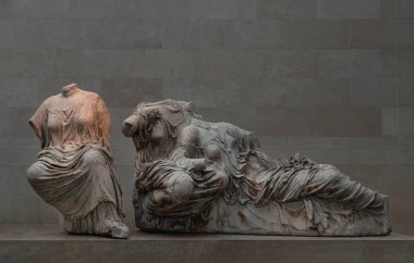 Londra, İngiltere - 31 Mayıs 2025 - Annesi Dione ile şömine tanrıçası Hestia 'nın kucağında uzanan Afrodit' in oyuncuları, Britanya Müzesi 'nin mermerinden yapılmış olan Parthenon' un doğu kanadından Yunan heykeli. Duvar kağıdın olarak kullan..