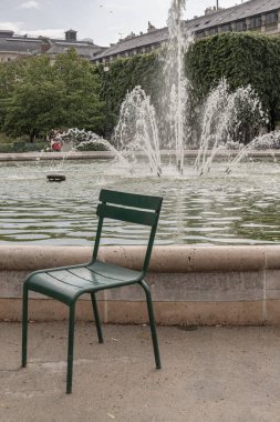 Fransa, Paris - Mayıs 03, 2025 - Tuileries Garden 'daki Jardin du Palais Royal Pınarında bulunan boş bir bahçe sandalyesinin görüntüsü. Duvar kağıdı olarak kullan, Poster ve Kopyala alanı, Seçici odak.