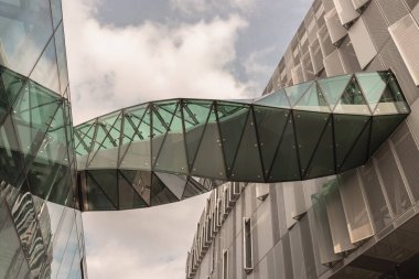 Londra, İngiltere - Haziran 09, 2025 - Lilywhite House (Tottenham Hotspur 'un kulüp ofisleri) ile New Tottenham Hotspur Stadyumu arasında bağlantı kuruldu. Twisted Sky Köprüsü 'nün fütüristik modern binalar arasındaki geçitin sersemletilmesi, uzayı kopyalamak..