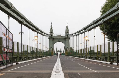 Londra, İngiltere - Haziran 09, 2025 - Hammersmith Köprüsü görüntüsü, Londra 'nın batısındaki Thames Nehri' ni geçen asma köprüdür. şimdi yayalar, bisikletçiler ve e-scooter 'a açıktır, bunu metin için duvar kağıdı, poster ve boşluk olarak kullanın.