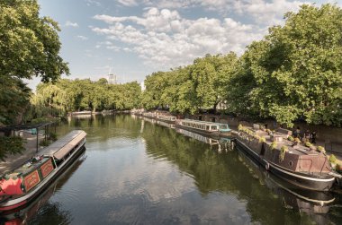 Londra, İngiltere - 21 Haziran 2025 - Batı Londra 'da Little Venice' in pitoresk bir alanı, Büyük Birlik Kanalı ve Regent Kanalı 'nın kavşak noktası, sakin kanalları ve dar kayıklar ve yüzen evlerle dolu su yolları. Duvar kağıdın olarak kullan.