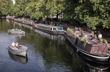 Turistler, Batı Londra 'daki Little Venice' de bir Waterdream teknesinde dinleniyorlar. Büyük Birlik Kanalı 'nın ve naiplerin kesişme noktası, sakin kanalları ve dar kayıklar ve yüzen evlerle dolu su yolları. Metin için boşluk.
