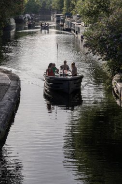 Turistler, Batı Londra 'daki Little Venice' de bir Waterdream teknesinde dinleniyorlar. Büyük Birlik Kanalı 'nın ve naiplerin kesişme noktası, sakin kanalları ve dar kayıklar ve yüzen evlerle dolu su yolları. Metin için boşluk.