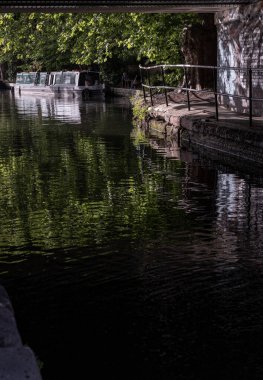 Londra, İngiltere - 21 Haziran 2025 - Batı Londra 'da Little Venice' in pitoresk bir alanı, Büyük Birlik Kanalı ve Regent Kanalı 'nın kavşak noktası, sakin kanalları ve dar kayıklar ve yüzen evlerle dolu su yolları. Duvar kağıdın olarak kullan.