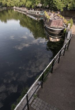 Londra, İngiltere - 21 Haziran 2025 - Batı Londra 'da Little Venice' in pitoresk bir alanı, Büyük Birlik Kanalı ve Regent Kanalı 'nın kavşak noktası, sakin kanalları ve dar kayıklar ve yüzen evlerle dolu su yolları. Duvar kağıdın olarak kullan.