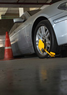 Bangkok, Tayland - 18 Ocak 2025 Otomobil Tekerleği 'nin dikey görüntüsü park alanında yasa dışı park ihlali nedeniyle tekerlek kilidi tarafından engellendi. Duvar kağıdı, poster ve kopyalama alanı olarak kullan, Seçici odak.