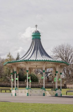 Newcastle, İngiltere - 13 Nisan 2025 - Bir Orkestra Sahnesi ve Bir Tribün Görünümü. Leazes parkına monte edilmiş Viktorya dönemi orkestrasının modern bir kopyası. Arka planda yeşil ağaçlar olan Müzik Pavyonu, Duvar Kağıdı olarak kullanın, Poster