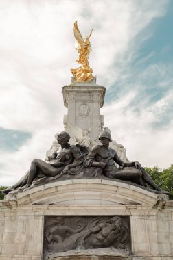 Zafer 'in bronz figürü, zırhlı figürle birlikte zırhlı figürle birlikte, Buckingham Sarayı önünde oturan kadın, Deniz Kuvvetleri ve Askeri Gücü sembolize eder. Boşluğu kopyala