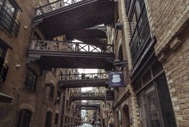 Shad Thames 'in ikonik caddesi boyunca manzaraya bakın ve tarihi kaldırımlı cadde, tuğla yapı ve Butlers Rıhtımı' ndaki depo dairelerini birbirine bağlayan köprüleri de içeren Viktorya dönemi depo mimarisine sahip..