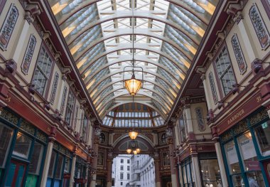Londra, İngiltere - 27 Haziran 2025 - Leadenhall Market 'in görkemli Viktorya mimarisi, doğal ışığın pazar alanını aydınlatmasına olanak sağlayan süslü, işlenmiş demir ve cam çatının bir kombinasyonudur. Duvar kağıdın olarak kullan, Poster.