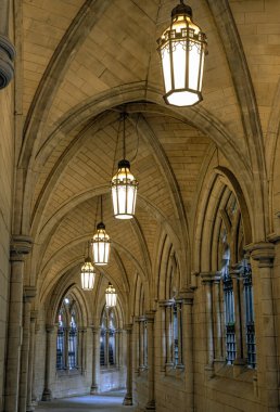 Londra, İngiltere - 27 Nisan 2025 - St. Mary Abbots Kilisesi 'nin girişinde tavandan sarkan antik fenerli kemerli bir koridor. Manastır kemeri perspektifi ve alışılmadık atmosferi olan koridor, bunu duvar kağıdı, poster ve kopyalama alanı olarak kullanın.