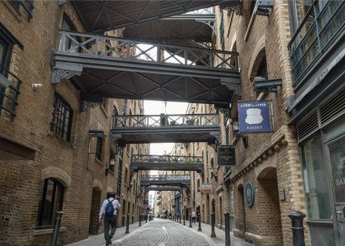 Shad Thames 'in ikonik caddesi boyunca manzaraya bakın ve tarihi kaldırımlı cadde, tuğla yapı ve Butlers Rıhtımı' ndaki depo dairelerini birbirine bağlayan köprüleri de içeren Viktorya dönemi depo mimarisine sahip.. 