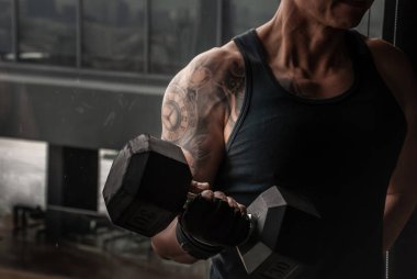 Bangkok, Tayland 06 Ekim 2019: Güçlü vücut geliştirici, spor salonunda ya da fitness kulübünde halterle kas pompalayan güçlü atletik adam.