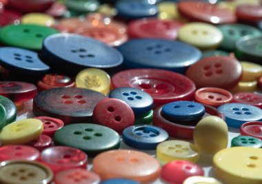 Farklı boyutlarda, gölgelerde ve desenlerde renkli dikiş düğmelerinin yakın çekimi. Çoklu Renkler süslü yuvarlak plastik düğmeler, zanaat arkaplanı, metin için duvar kağıdı, poster ve boşluk olarak kullanın, Seçici odak.