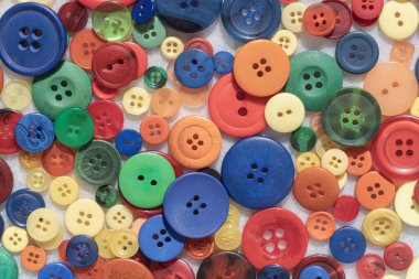 Renkli dikiş düğmelerinden oluşan çeşitli bir koleksiyonun üst görüntüsü. Çeşitli şekiller, boyutlar ve kalıplar. Çoklu Renkler süslü yuvarlak plastik düğmeler, zanaat arkaplanı, metin için duvar kağıdı, poster ve boşluk olarak kullanın, Seçici odak.