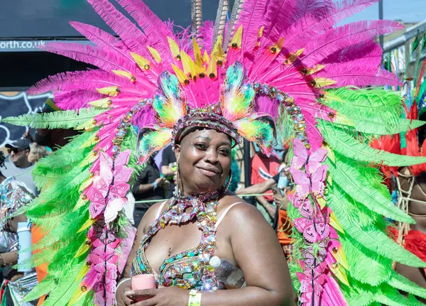 Sanatçı, Notting Hill Karnavalı 'nın büyük, tüylü başlığı ve süslü mücevherleriyle süslü renkli ve çetrefilli bir kostüm giyerek Karayip kültürü ve tarihi kutlamalarıyla tanınıyor.