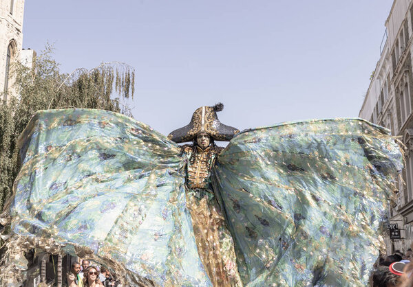 a performance individuals in elaborate, distinct costumes and a detailed headpiece resembling a headdress with horns or spikes at the Notting Hill Carnival in West London, its widely recognized for its celebration of Caribbean culture and history.