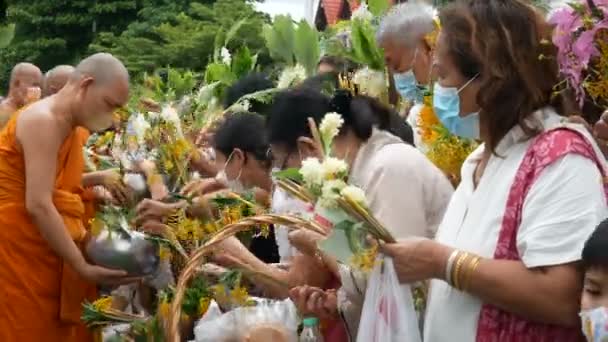 2022年7月13日タイ サラブリ プラフタバト寺院での仏教徒貸出日中の仏教の伝統における僧侶のための花の供養祭 メリットフラワーフェスティバル に出席する仏教徒 — ストック動画