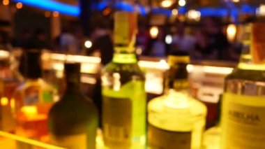 Barmen karışımının odak noktasını bozmak ve ön planda bir şişe likör bulunan bir müşteriye alkollü kokteyl içeceği ikram etmek. Gece hayatı geçmişi için görüntüler