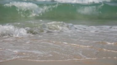 4 bin. Mavi okyanus dalgalı dalgalı beyaz kumsalın yavaş çekimleri tropik deniz arka planı, yaz tatili ve seyahat konsepti için sıçrama yapıyor.