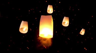 Kuzey Tayland 'daki Chiang Mai' de Loy Kratong Festivali sırasında Yi Peng geleneği için arka planda yüzen bir sürü fenerle el feneri gökyüzüne salıyor.