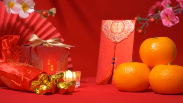 中国の旧正月の背景 赤いテーマ シルクバッグの金 金の弓 紙ファン Tae Eiaの封筒 赤い封筒 オレンジ 梅の花の枝 — ストック動画