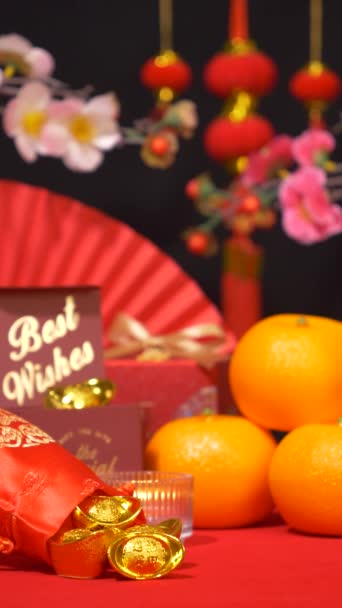 赤い中国の旧正月の背景のループ 絹袋の金 テキストの最もよい願い オレンジ ペーパー ファン 梅の花の枝 ろうそくの揺れおよび祝うための中国の新年の装飾が付いている赤いギフト用の箱 — ストック動画