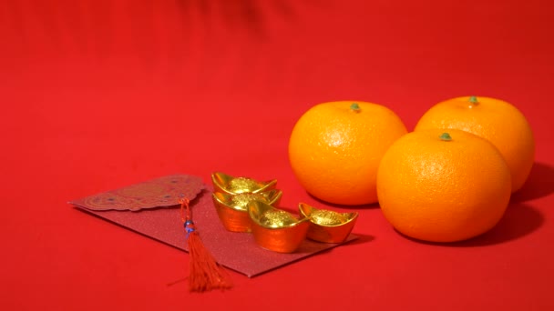 中国の旧正月の赤い背景のループ 古代中国の金の棒 オレンジ 赤い封筒 パワー 中国の新年にお金を与えるための赤いパケットは葉の影の揺れで祝います — ストック動画