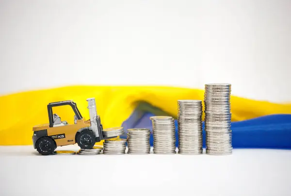 Bir forklift, demir çubuklar şeklinde büyüyen bir grafiğe karşı madeni para kaldırıyor. Bu, iş büyümesini, karı ve finansal başarıyı simgeliyor. Finans, yatırım veya işletme üzerine makaleler ve sunumlar için mükemmel.