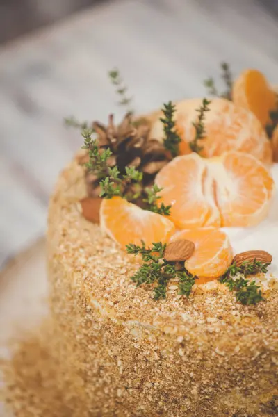 Ahşap bir arka planda tereyağlı ballı pasta ve kış süsü.