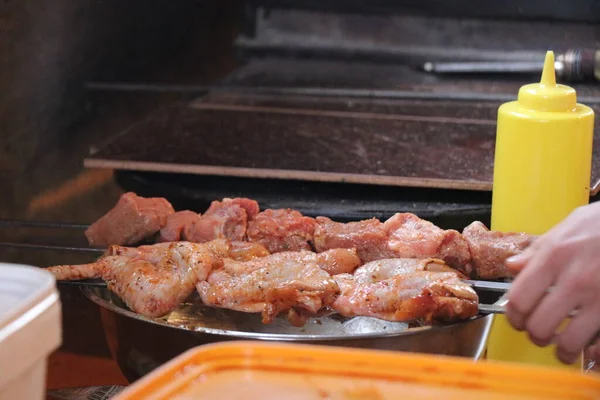 鸡腿和鸡翼是在一个巨大的石烤炉的炉火上烹调的 篝火边的美味食物 肉馅烤肉是一种丰盛营养的食物 — 图库照片