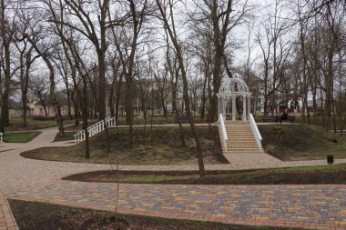 Baharda güzel bir park. Eski parkın yolları yeni çardaklara açılıyor. Park alanında genç ağaçlar çiçek açmaya başlar.