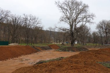 Baharda güzel bir park. Eski parkın yolları yeni çardaklara açılıyor. Park alanında genç ağaçlar çiçek açmaya başlar.