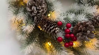 Çam kozalaklı Noel çelengi, kırmızı böğürtlen ve çelenk. Noel için kapıları süslemek için çelenk