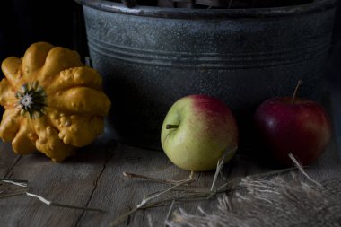 Ahşap zeminde çizgili balkabağı ve elmalar
